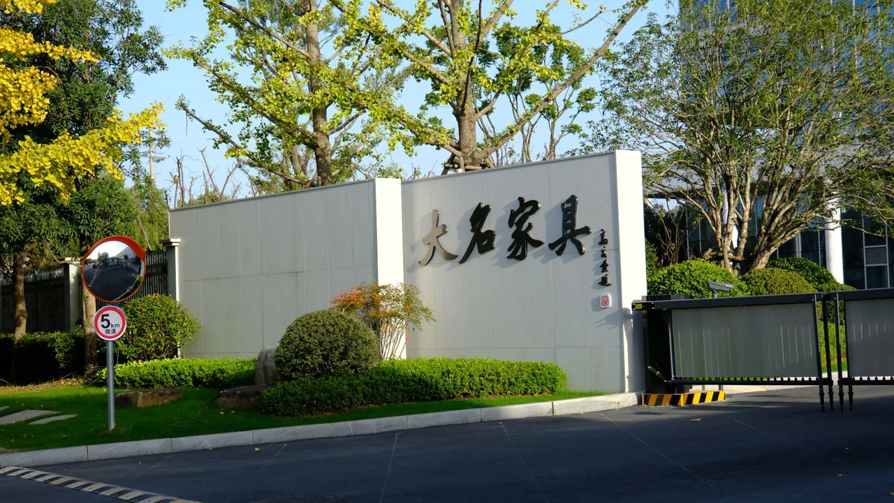Factory entrance gate of Zhejiang Anji Daming Furniture with the company name 大名家具 carved on the wall